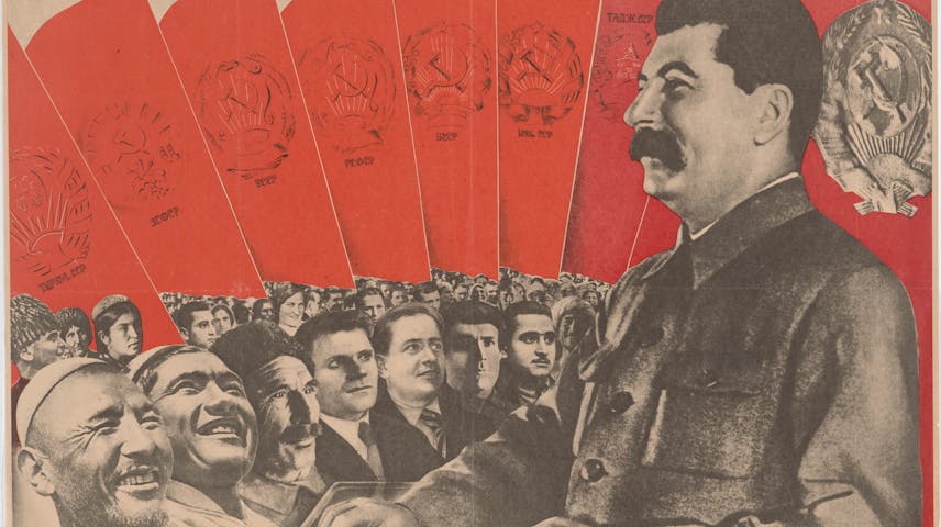 Photo-style poster showing Joseph Stalin smiling out at a collection of diverse smiling faces. The caption says in Russian: “Long live the USSR, model of brotherhood among the workers of world nationalities.”