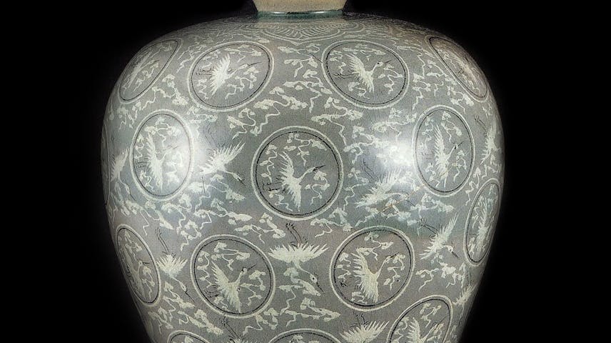 A large vase with a design of inlaid clouds and crane birds.