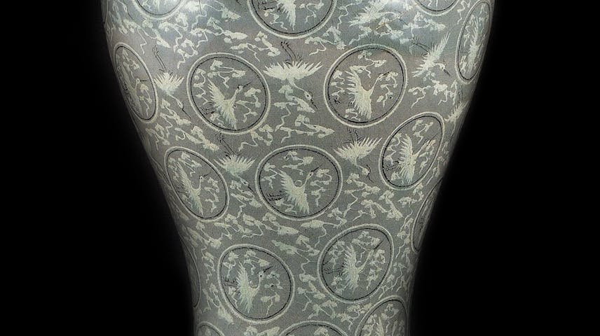 A large vase with a design of inlaid clouds and crane birds.