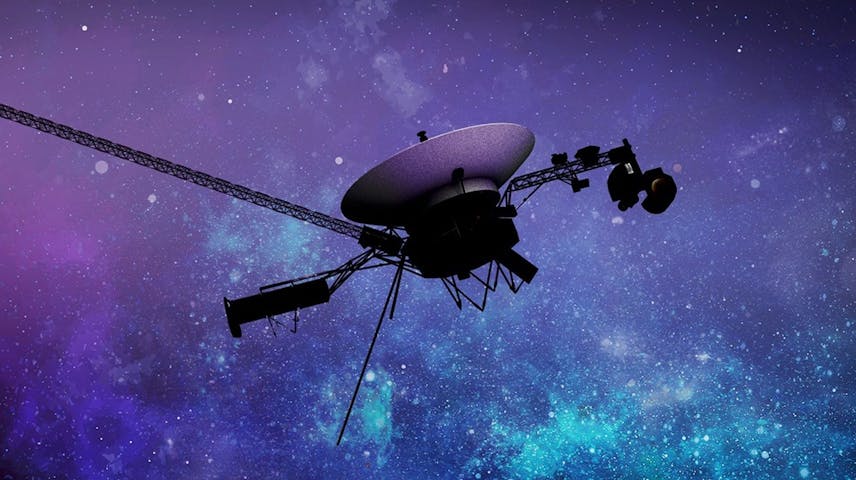 Artist's illustration of the Voyager spacecraft floating in deep space. The probe has a large round dish antenna on top, connected by metal beams to a central body with scientific instruments and long antennae extending outward. The background shows a stunning purple and blue starfield, representing the vast universe beyond our solar system.