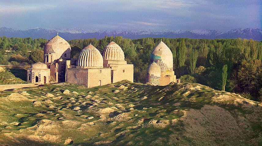 Several old stone domed buildings in a mountainous region.