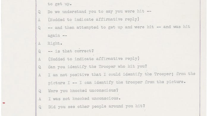 A scanned page (numbered 296) from an old typed legal document showing a question-and-answer interview, similar to a courtroom testimony. A person describes being knocked down and struck twice on the head with a billy club by a State Trooper during a chaotic scene where people were being pushed and knocked over. The person says they were not knocked unconscious and could identify the trooper from a photograph. The Q and A format shows a questioner (Q) asking follow-up questions and the witness (A) answering them.