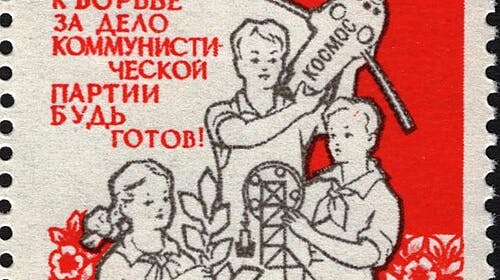 A postage stamp showing a drawing of kids with a rabbit, a plant, a model plane, and an engineering toy and the slogan, “Prepare to fight for the cause of the Communist Party.”