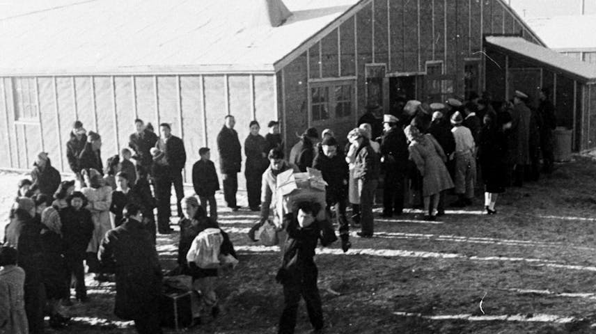 A black and white photo of a group of Japanese Americans arriving at a world war 2 detention center called Tule Lake